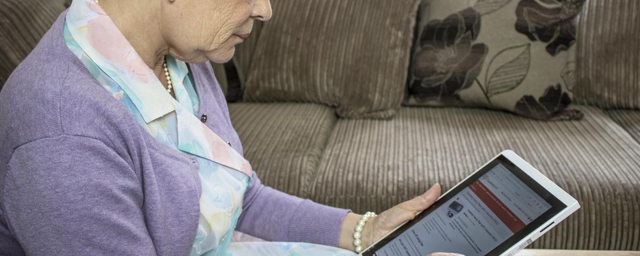 Elderly lady on her iPad looking at the Careline website