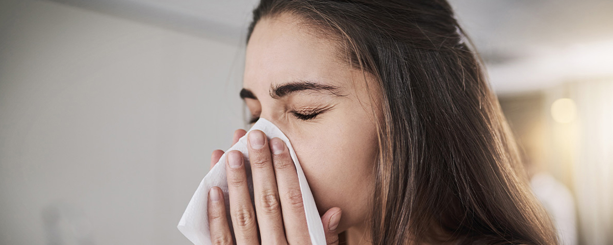 Lady blowing her nose into a tissue