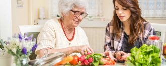 Elderly mum and daughter cooking