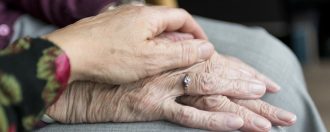 Elderly couple holding hands